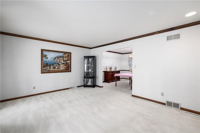 spare room with light carpet, an inviting chandelier, and ornamental molding