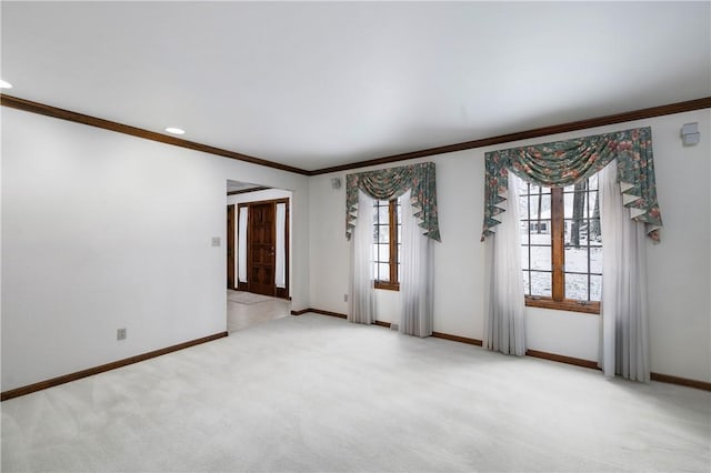 unfurnished room featuring light colored carpet, crown molding, and a healthy amount of sunlight