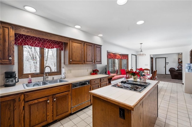 kitchen featuring pendant lighting, stainless steel gas stovetop, dishwasher, sink, and a kitchen island