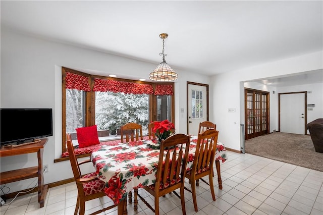 carpeted dining space with a chandelier