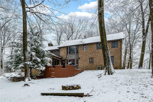 snow covered back of property featuring central AC unit