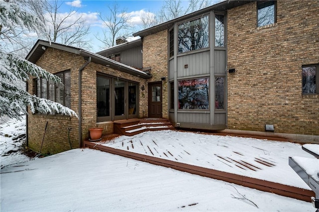 snow covered property featuring a deck