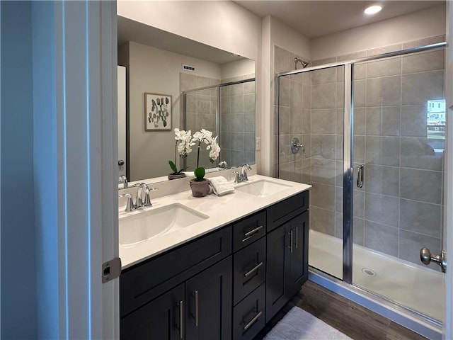 bathroom with hardwood / wood-style floors, vanity, and walk in shower