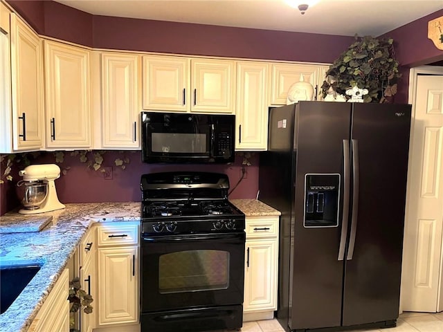 kitchen featuring black appliances, light tile patterned flooring, light stone countertops, and sink