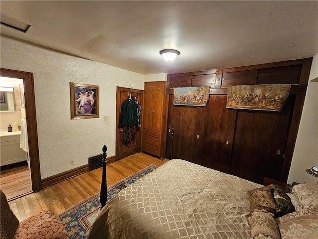 bedroom featuring light hardwood / wood-style floors and ensuite bath