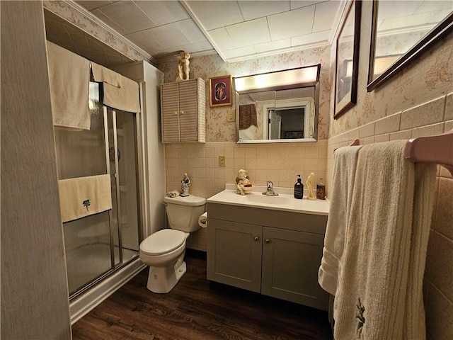 bathroom featuring vanity, a shower with shower door, toilet, ornamental molding, and wood-type flooring