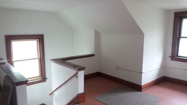 stairway featuring hardwood / wood-style floors and vaulted ceiling