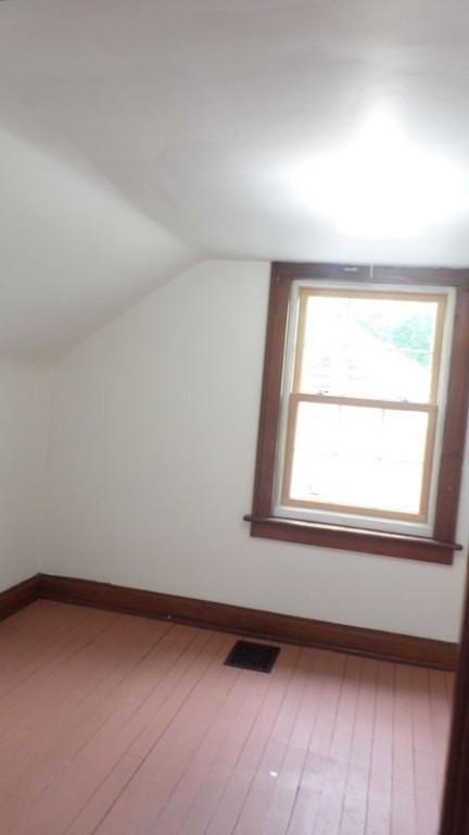 additional living space featuring lofted ceiling