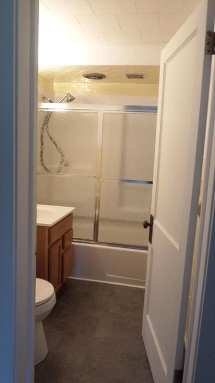 full bathroom with shower / bath combination with glass door, vanity, and toilet