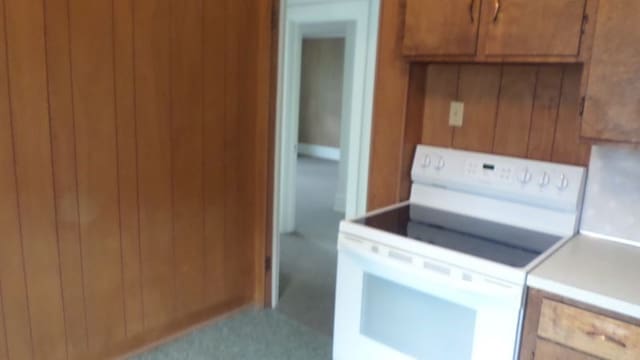 kitchen featuring wood walls and white electric stove