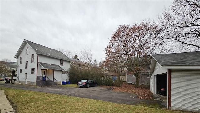 view of side of home featuring a garage and a lawn