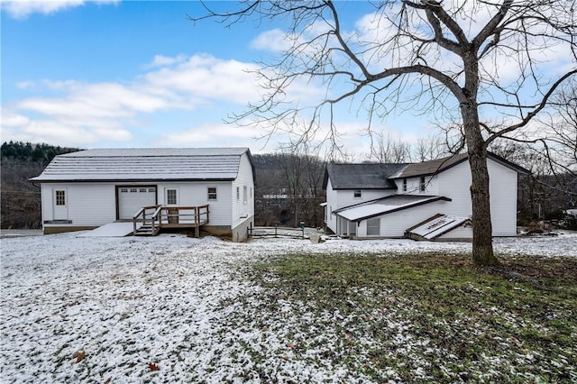 snow covered rear of property with a wooden deck