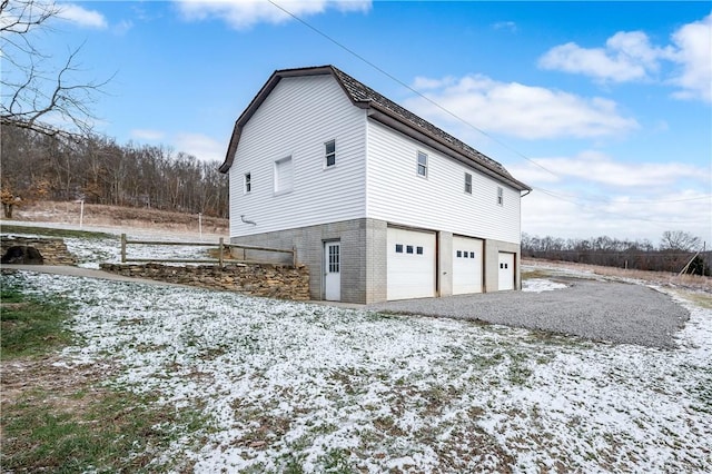 view of snow covered exterior with a garage