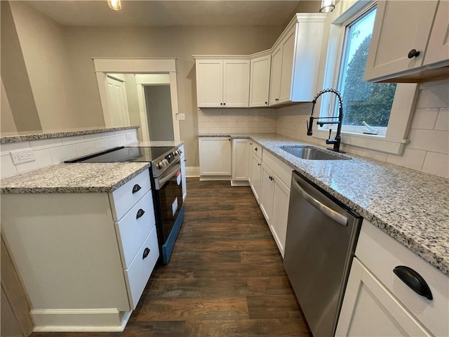 kitchen featuring light stone countertops, stainless steel dishwasher, sink, electric stove, and white cabinetry