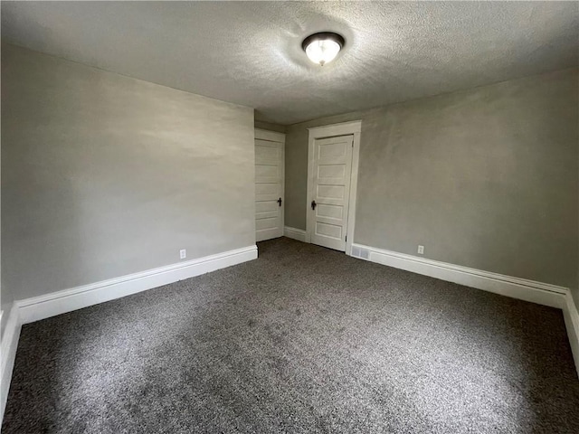 carpeted empty room with a textured ceiling