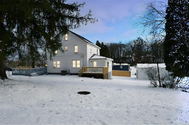 snow covered house with a wooden deck