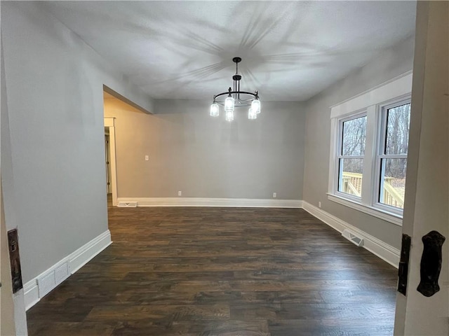 unfurnished dining area with dark wood-type flooring and a notable chandelier