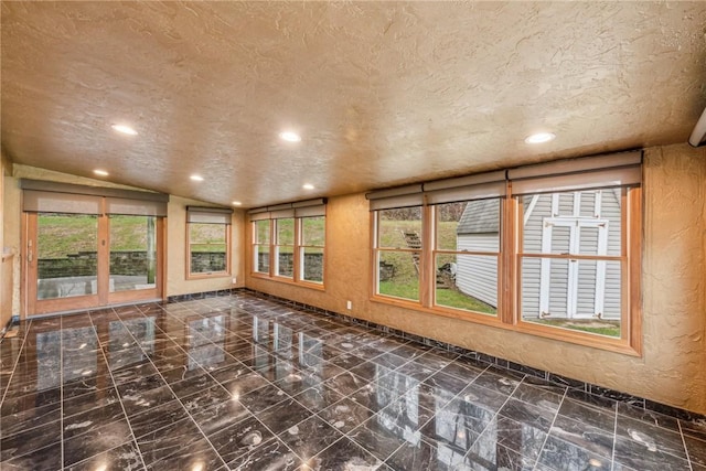 interior space with a textured ceiling and lofted ceiling