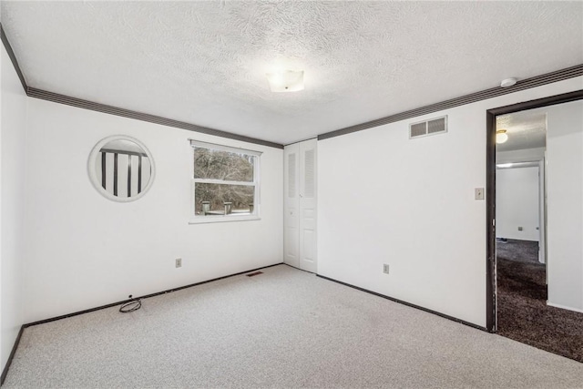 unfurnished room with carpet floors and a textured ceiling