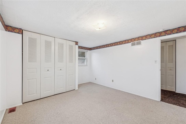 unfurnished bedroom featuring carpet and a textured ceiling