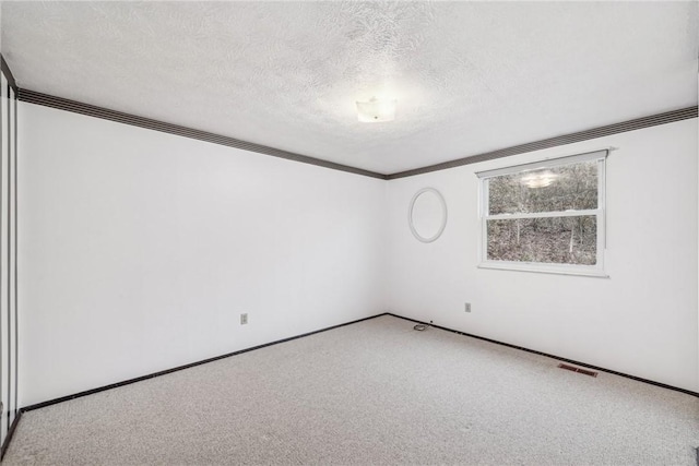 unfurnished room featuring carpet flooring and a textured ceiling