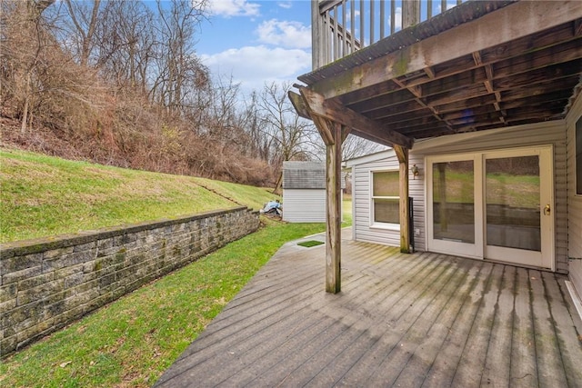 wooden terrace with a lawn and a storage unit