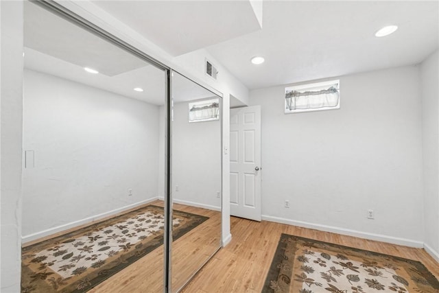 basement with light hardwood / wood-style flooring