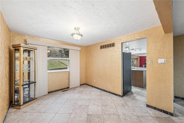 unfurnished room featuring a textured ceiling