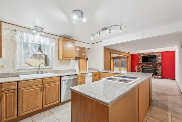 kitchen featuring a brick fireplace, stainless steel dishwasher, electric stovetop, sink, and a center island