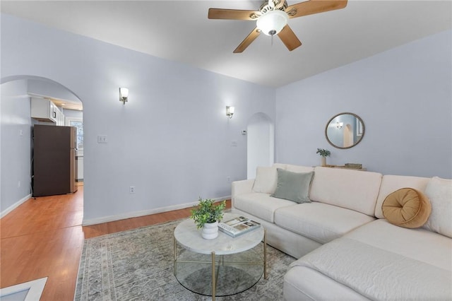 living room with ceiling fan and light wood-type flooring