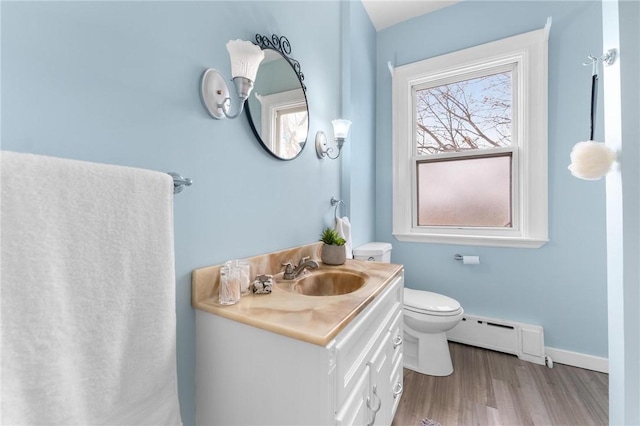 bathroom with vanity, a healthy amount of sunlight, toilet, and a baseboard heating unit