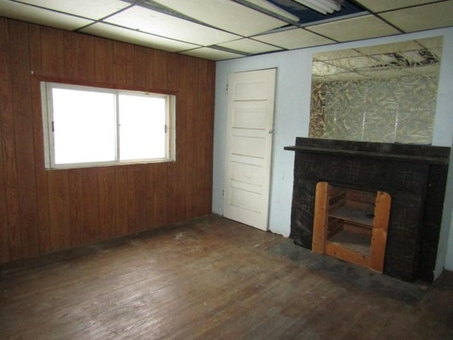 unfurnished living room with dark hardwood / wood-style floors and wood walls