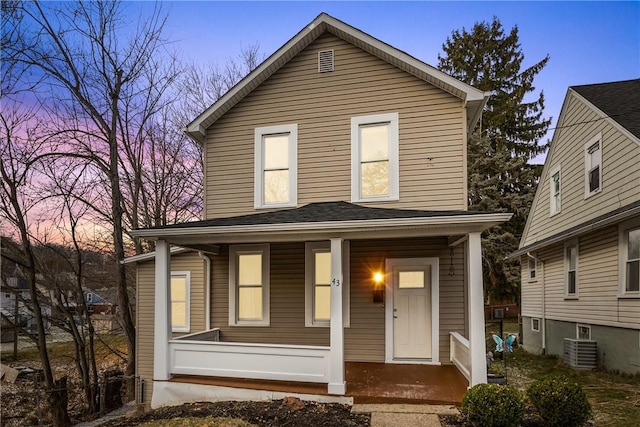 view of front property featuring a porch and cooling unit