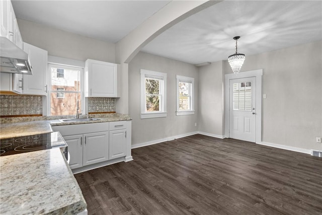 kitchen featuring decorative light fixtures, white cabinetry, sink, and tasteful backsplash