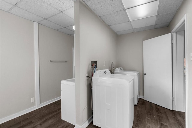 clothes washing area with washer and clothes dryer and dark hardwood / wood-style floors