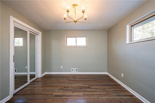 unfurnished dining area with dark hardwood / wood-style flooring and a notable chandelier