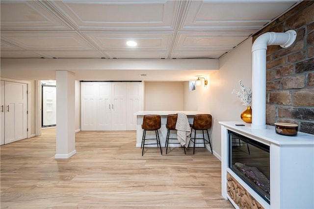 bar with beverage cooler and light hardwood / wood-style floors