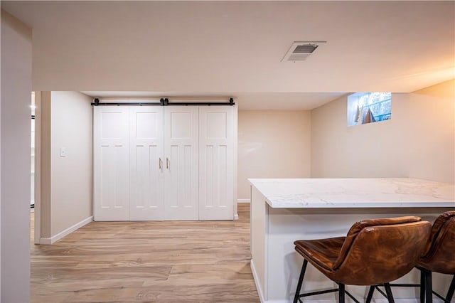 interior space featuring a kitchen breakfast bar and light hardwood / wood-style flooring