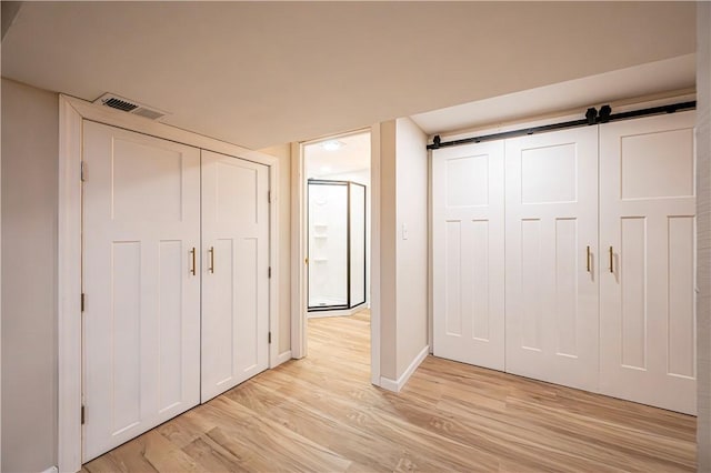 interior space with a barn door and light hardwood / wood-style floors