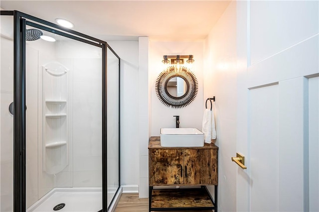 bathroom with a shower with door, vanity, and hardwood / wood-style floors