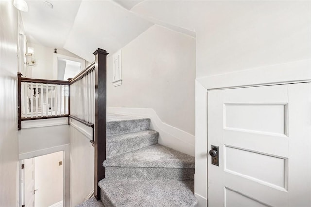 stairway with carpet and vaulted ceiling