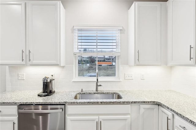 kitchen featuring backsplash, white cabinetry, stainless steel dishwasher, and sink