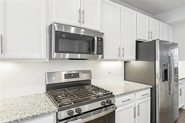 kitchen featuring decorative backsplash, white cabinetry, and stainless steel appliances