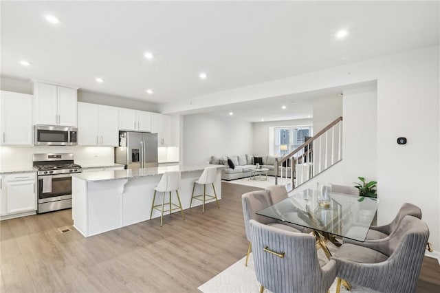 kitchen with white cabinets, light stone countertops, and stainless steel appliances