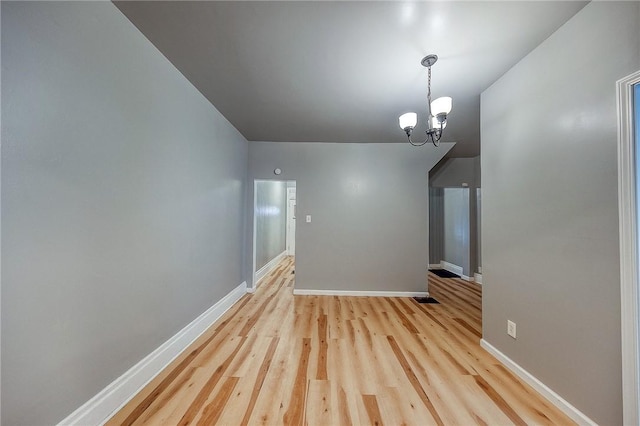 unfurnished living room with light hardwood / wood-style flooring and an inviting chandelier