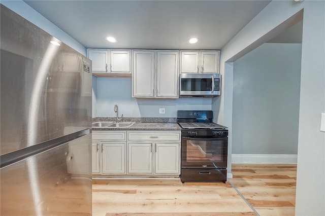 kitchen featuring light hardwood / wood-style flooring, stainless steel appliances, white cabinetry, and sink