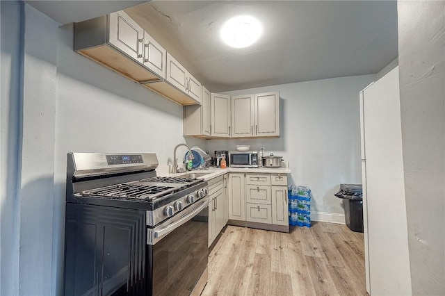 kitchen with sink, stainless steel appliances, and light wood-type flooring