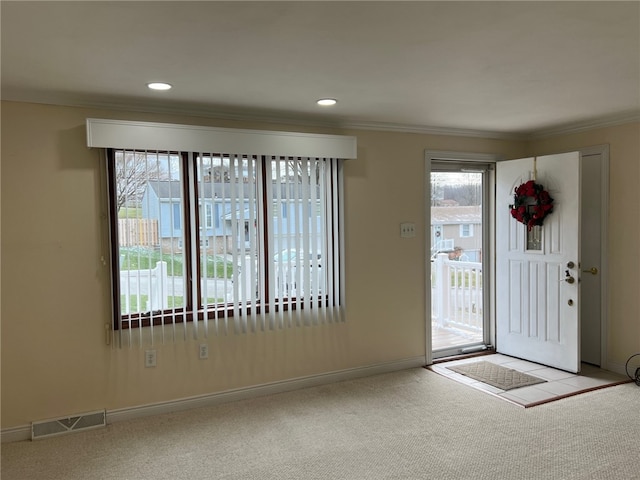 carpeted entryway with crown molding