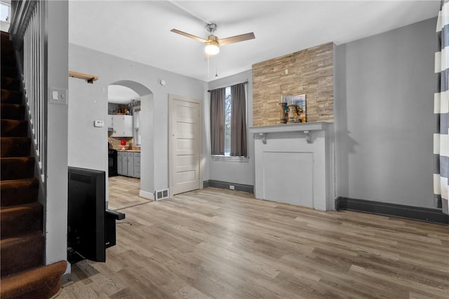 unfurnished living room featuring ceiling fan and light wood-type flooring