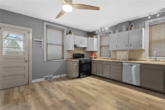 kitchen with decorative backsplash, dishwasher, black gas stove, and sink